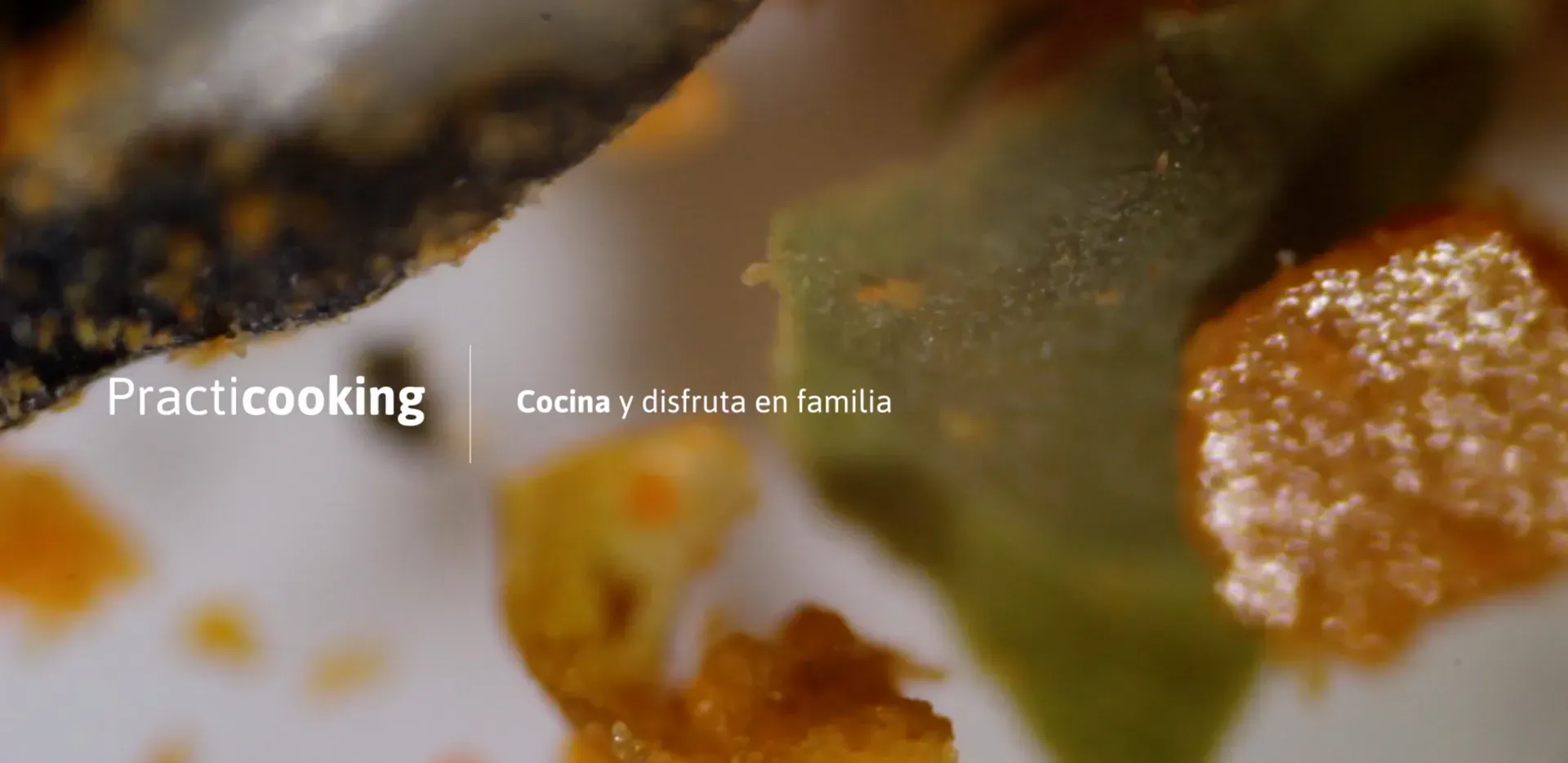 Fotograma del vídeo: plano muy cerrado de verduras y salsa, con el rótulo «Practicooking Cocina y disfruta en familia»