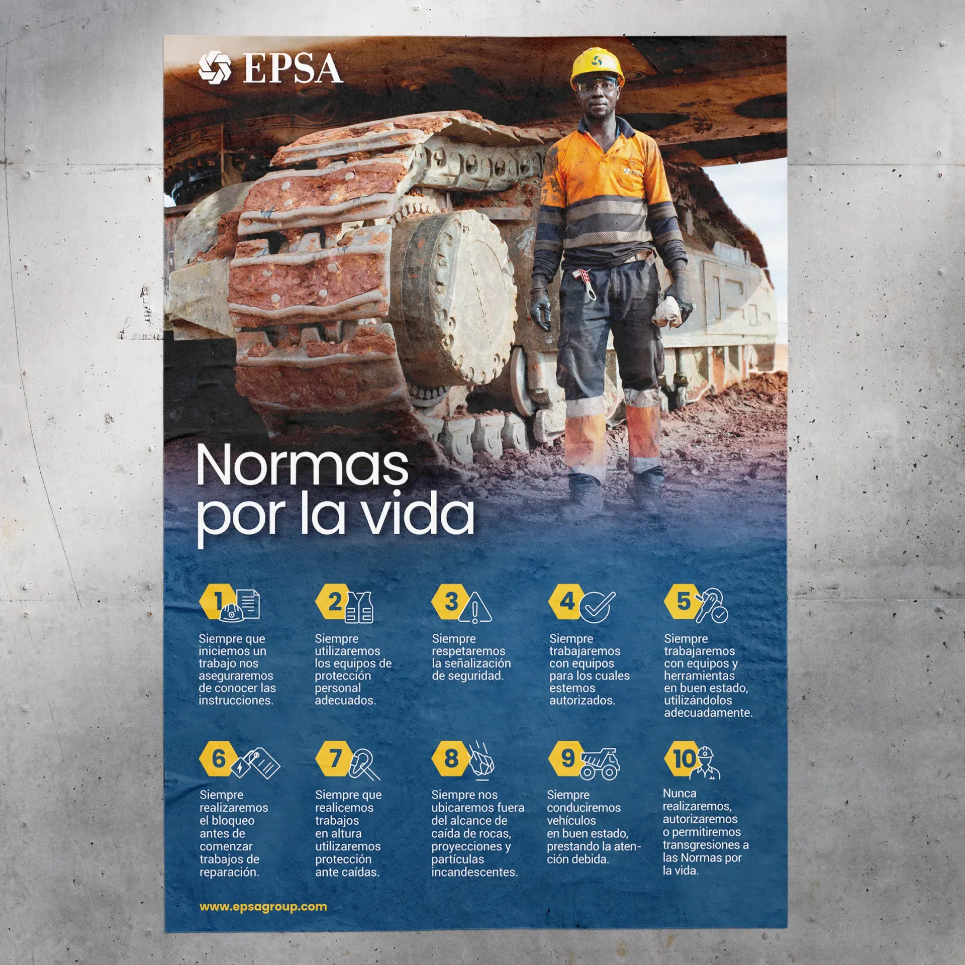 Un cartel pegado en un muro de hormigón: un operario con casco amarillo junto a la oruga de una máquina, el título «Normas por la vida» y diez normas numeradas con su icono sobre fondo azul